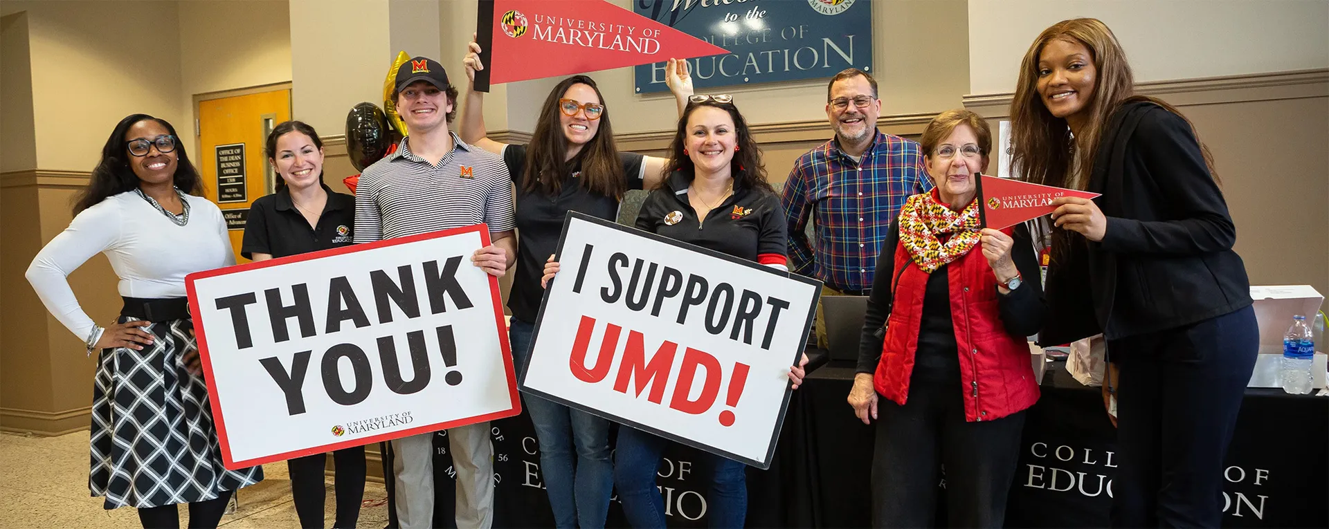 Lots of people with signs that say Thank You! and I Support UMD!
