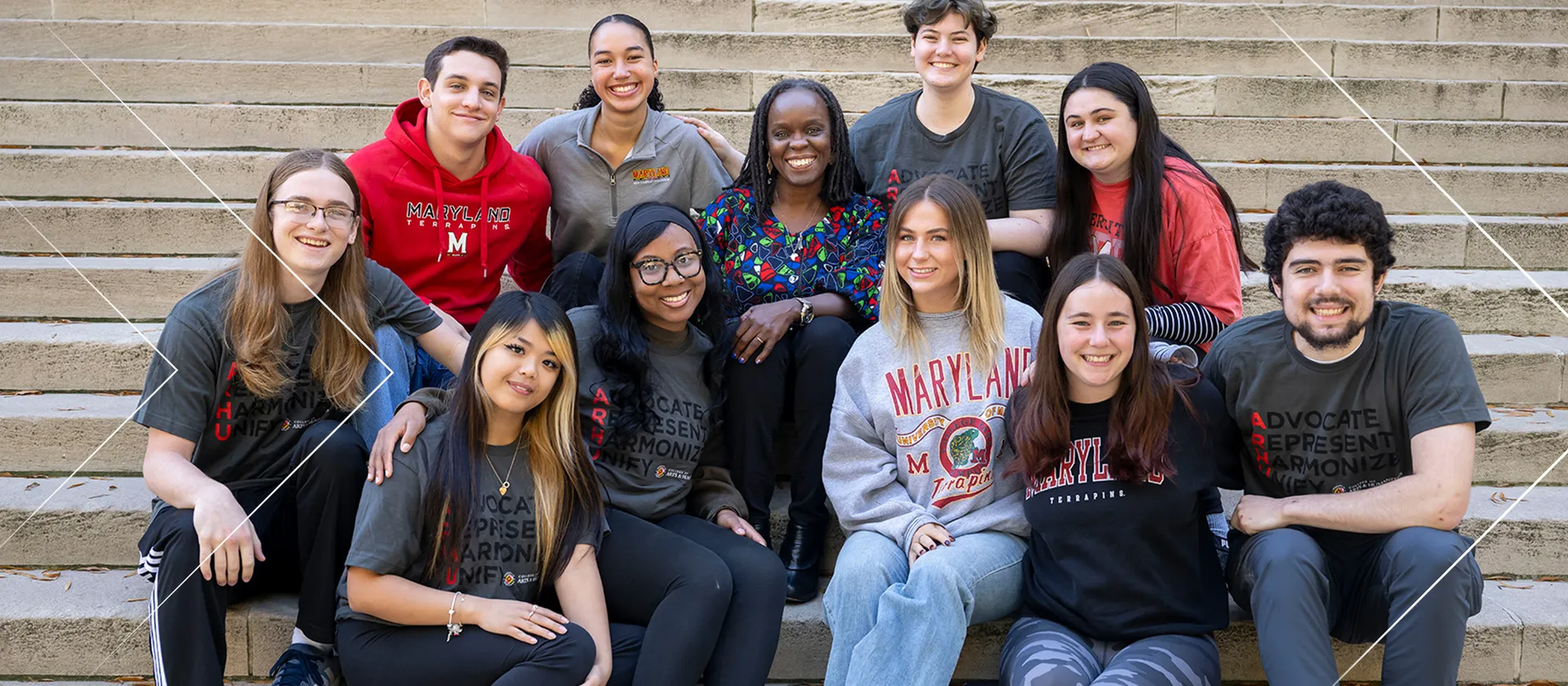 A group of 10 students sit around the dean of the University of Maryland College of Arts and Humanities, all of them positioned on a set of stairs.