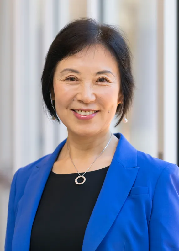 A woman wearing a suit smiles.