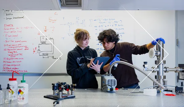 Students working in a chemistry lab in front of a whiteboard