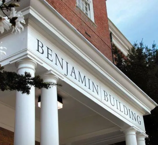 The exterior of a brick building, with columns and a space where letters spell out "Benjamin Building."