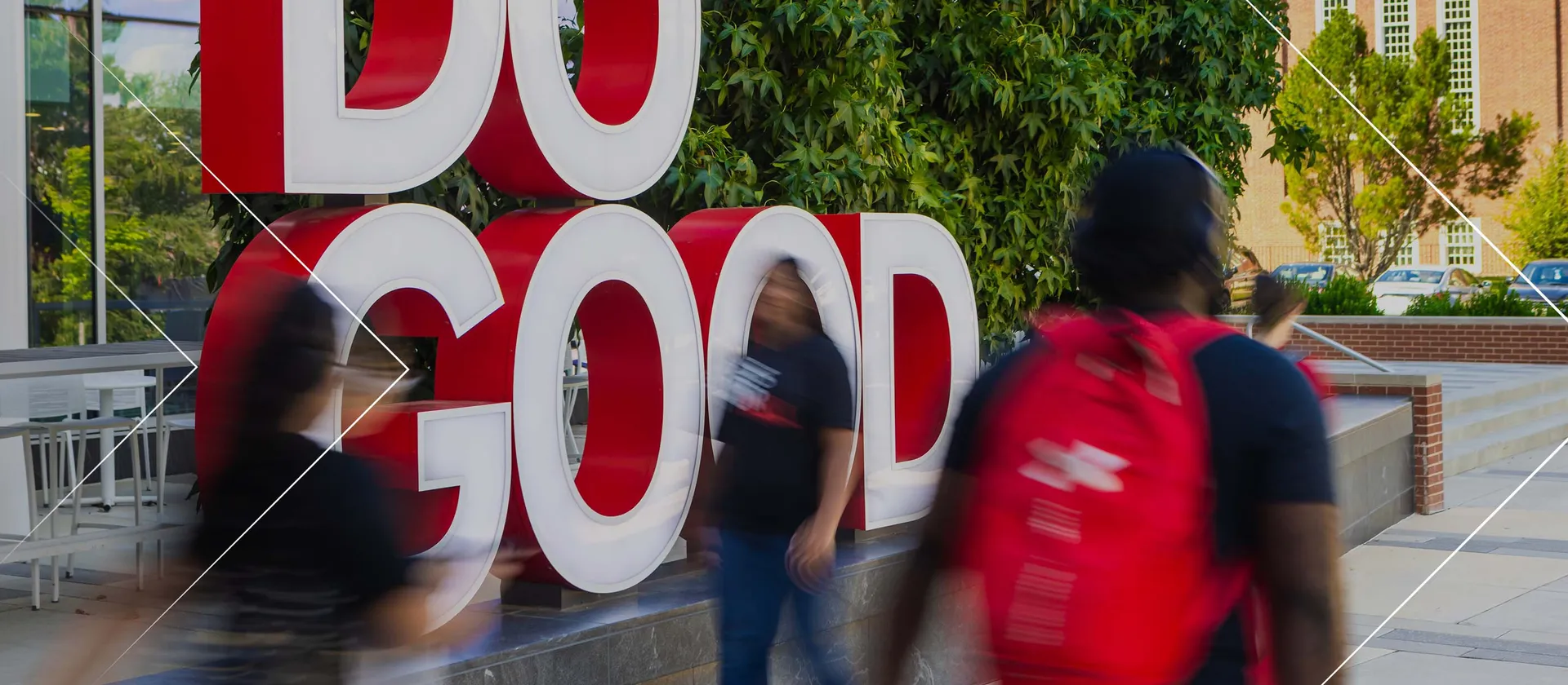 Students rushing around Do Good sculpture