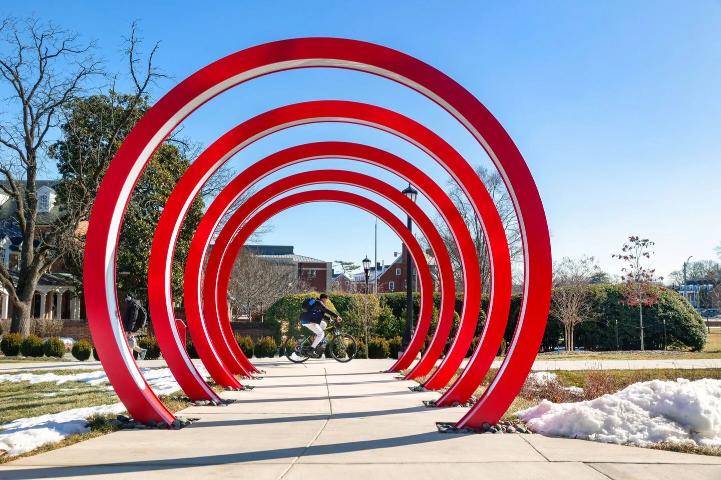 Do Good red rings over a sidewalk. Bike rider in the background